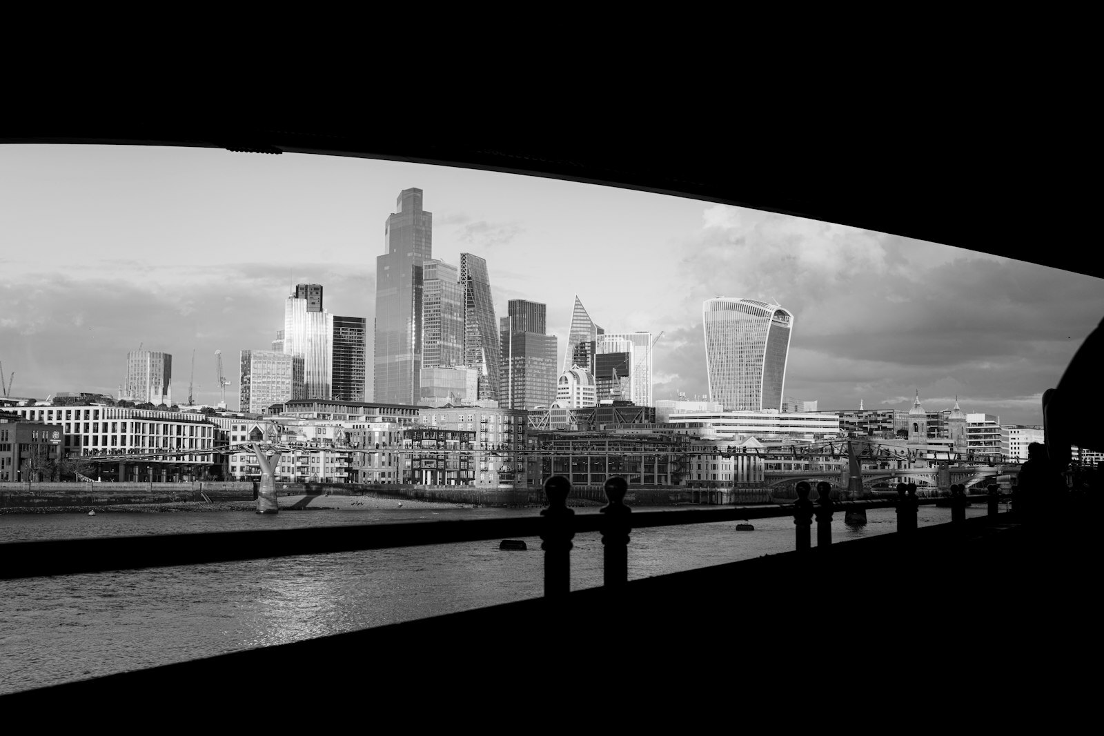 Modern city skyline with river and bridge in foreground